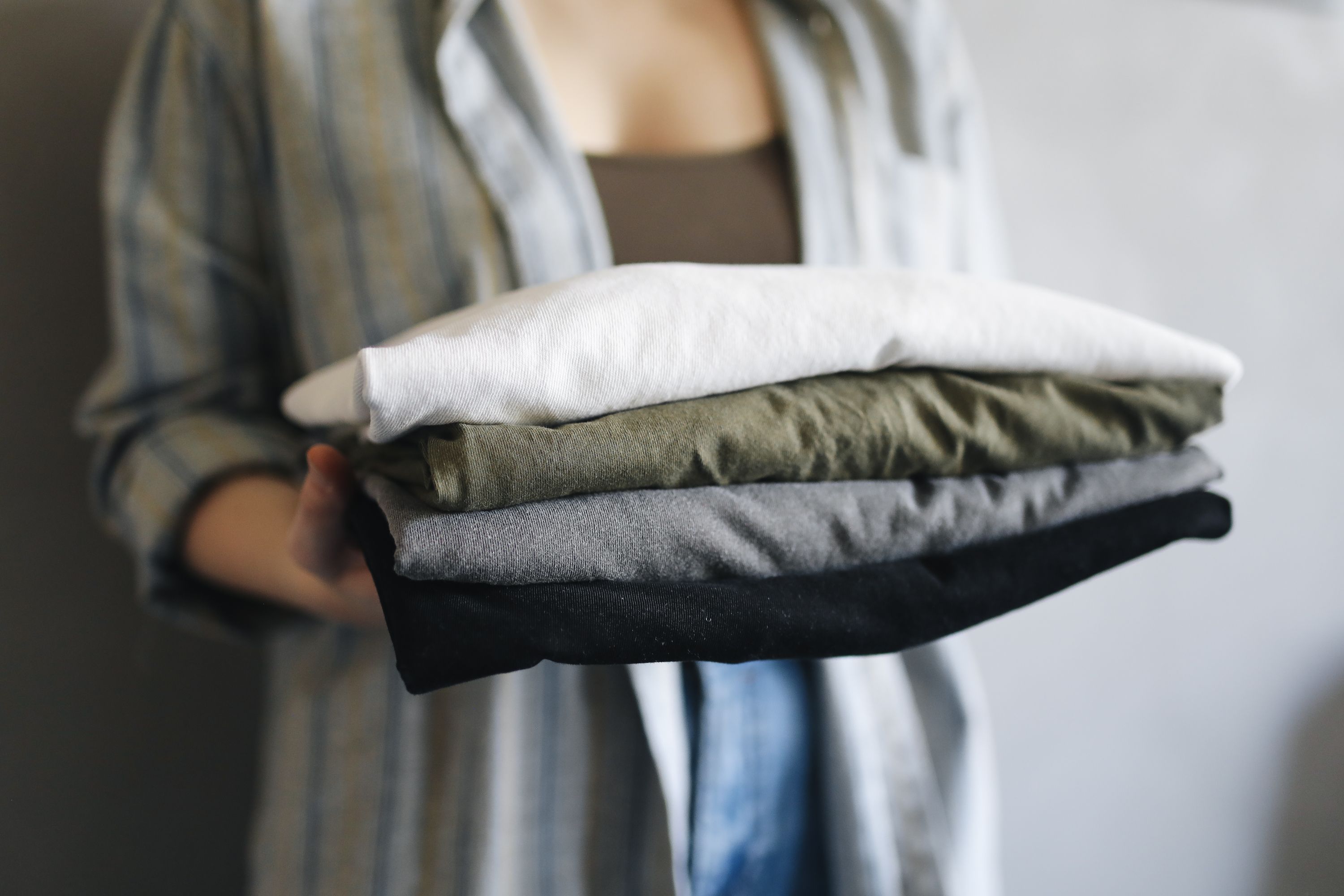 Pile de linge fraîchement plié, tenue dans les bras